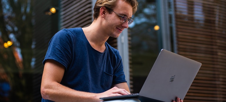a man reading on a laptop about moving from San Diego to Miami