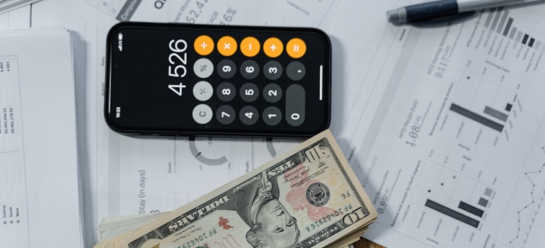 Calculator, pen and paper, and money