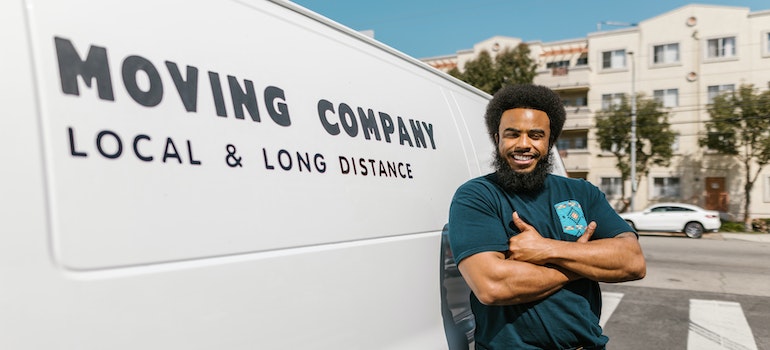 A man in front of a moving company van