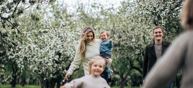 A couple and their children running in nature.