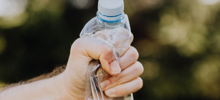 holding plastic bottle while trying to make your Miami move sustainable