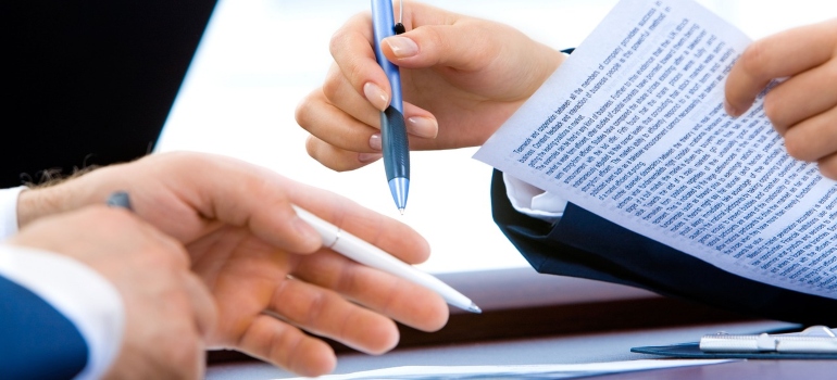 a woman and a man signing papers