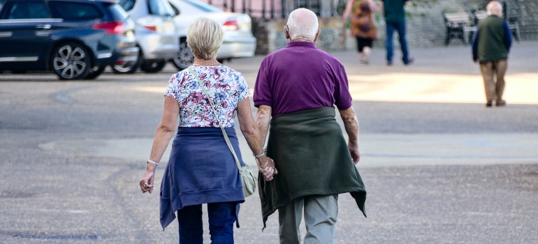 Two old people walking in the street after reading our Miami guide for seniors