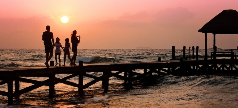 family standing on a pier at sunset