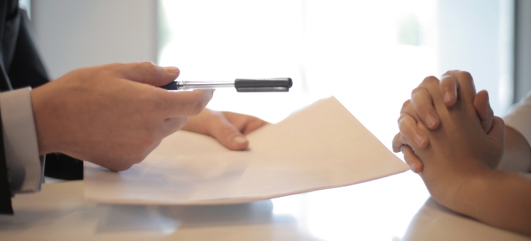 man and woman signing a document after checking the Miami real estate market