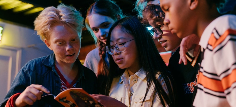 A group of teenagers reads about the best cities in FL for moving with teenagers.
