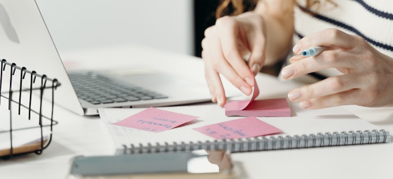 Woman writing on sticky notes