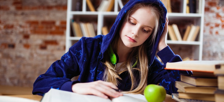 The girl is studying at the table.