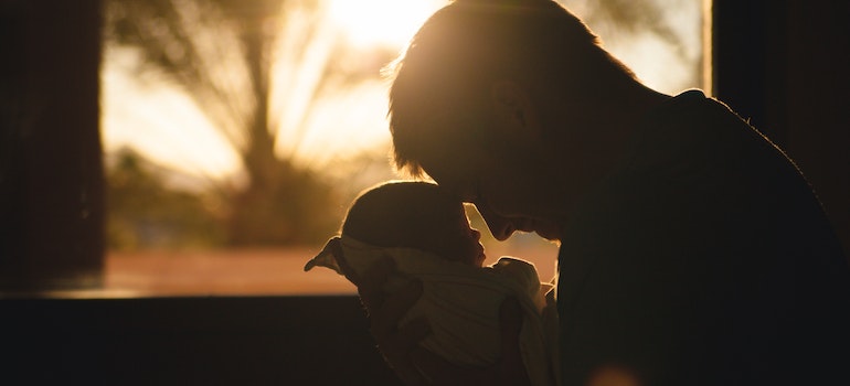 A man carrying his newborn after moving to Florida