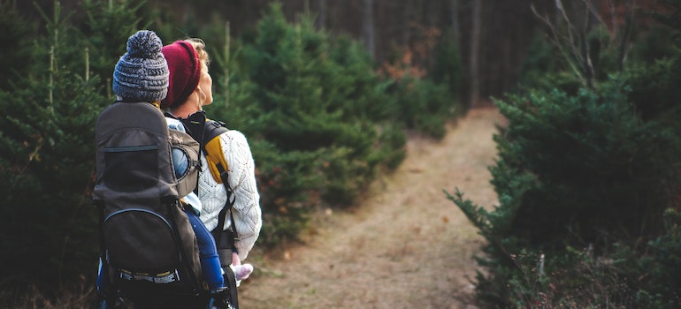 A woman hiking with a baby on her back through some of the stunning hiking destinations in Florida.