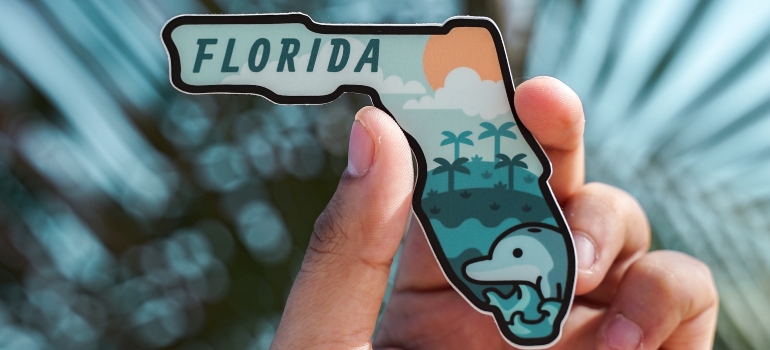 a person holding a Florida fridge magnet and thinking about the reasons why expats love Florida