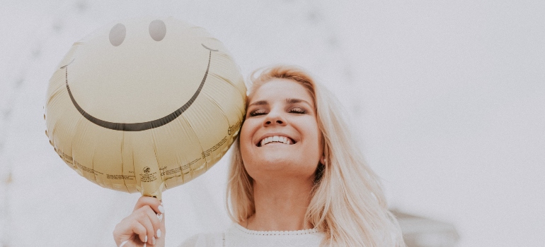 woman smiling and holding a baloon