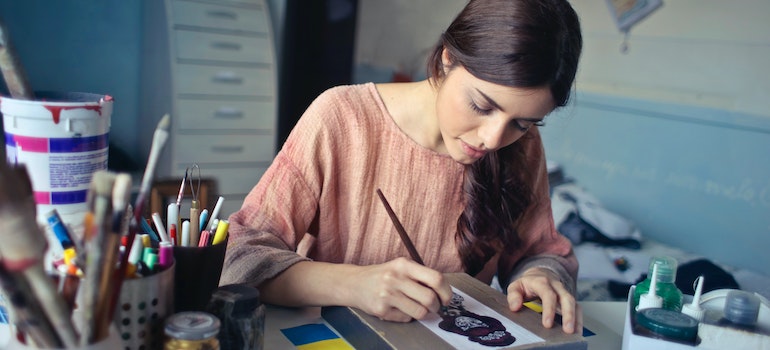 A woman painting something on a paper.