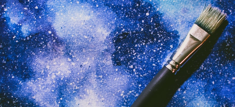 A brush resting against a painting.