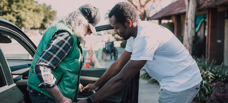 A man helping an elderly woman