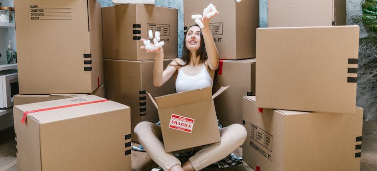 woman among moving boxes getting ready for packing a moving truck