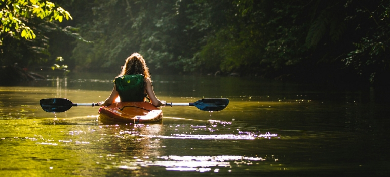 woman riding kayak after moving and fishing in Weston