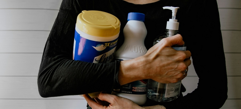 woman holding cleaning supplies