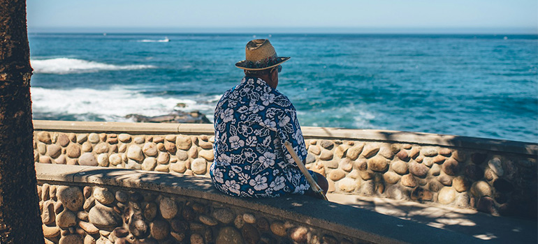 old man sitting by the ocean