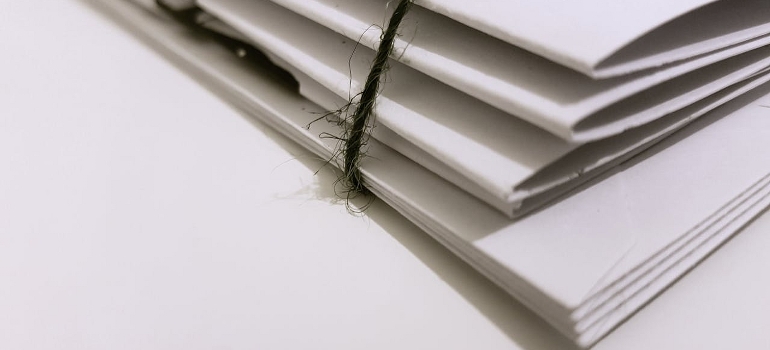 stack of documents as one of the things that you should bring in your car when moving