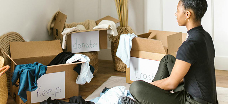 woman sorting stuff and thinking about the things to do while the movers work