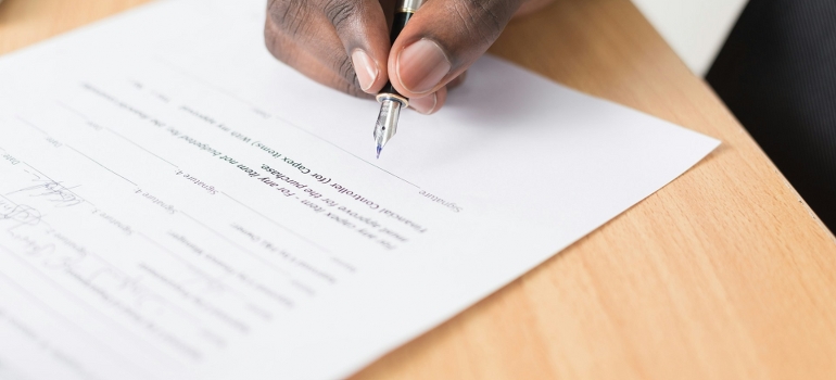 signing a paper for a hotel move to Miami