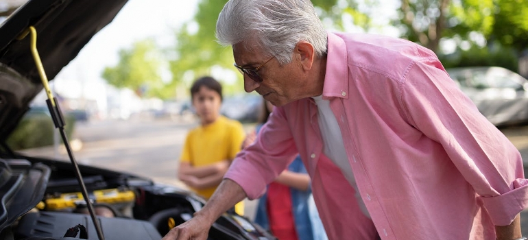 old man doing car checks before moving