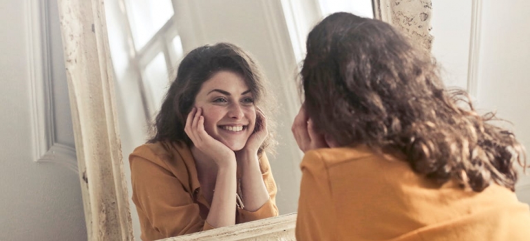 woman looking herself in a mirror