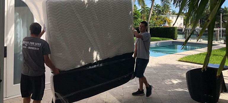 Movers carrying packed furniture